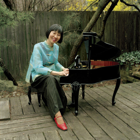 Margaret Leng Tan sitting outside with a toy grand piano.